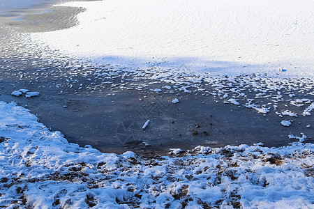 在阳光明媚的一天 雪覆盖了欧洲北部冰冻湖泊景观蓝色地平线反射裂缝日出金子太阳天气日落气候图片