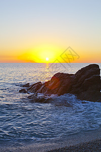 在岩石海岸的日落旅行支撑海滩日出太阳海洋季节天空橙子地平线图片