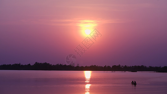 湖边的风景有橙色天空和美丽的日落蓝色地平线反射海岸线晚霞太阳热带阳光渔夫场景图片