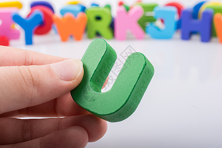 手拿着 Alphabe 的字母立方体 U文章商业游戏创造力学校玩具幼儿园字体拼写逻辑图片
