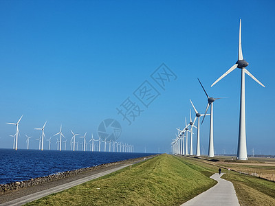 湖旁的风车村侵扰性风力厂活力能源天空绿色电气发电机公园海洋生产蓝色图片