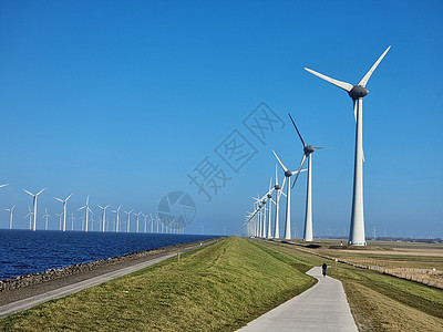 湖旁的风车村侵扰性风力厂风车天空场地活力蓝色公园力量全球电气发电机图片