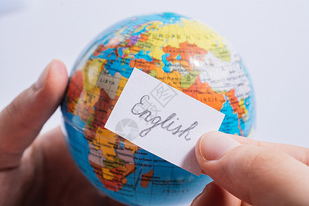 手持全球使用英文文字的纸上随笔纸知识学习全球化教育英语旅行班级说话指导语言学图片