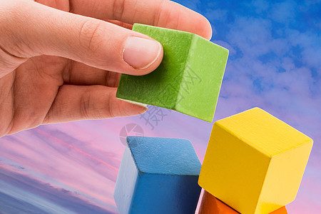 在背景上手工构建彩色立方体建造战略玩具解决方案游戏建筑几何学难题孩子数字图片
