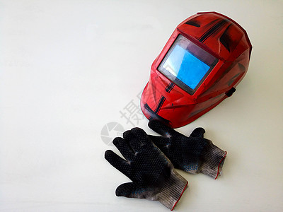 肮脏焊接手套的照片 在车间的焊接器面罩上图片