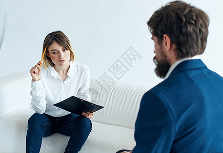 穿着经典西装的商务人士和坐在沙发上 文件在心理学家手中工作的妇女 (b) 女图片