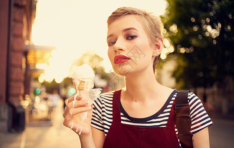 长短头发吃冰淇淋的漂亮女人 在户外休闲散步潮人食物喜悦太阳镜旅行微笑城市假期女性快乐图片