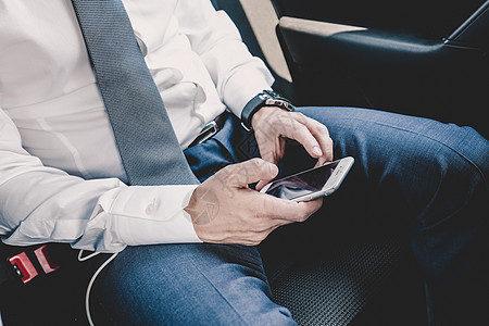 近距离的商务人士在汽车里使用移动智能手机数据经纪人男性男人贸易商务技术管理人员领带收费图片