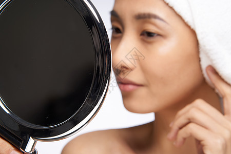 女人手里拿着镜子 佩服自己 干净的皮肤贴近她治疗毛巾女性女孩护理皱纹面具剥皮身体微笑图片