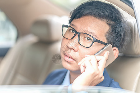 商务人士在汽车的后座工作技术电话领带经理车辆出租车商务座位男性眼镜图片