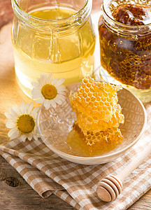 特写蜂窝 在玻璃罐中加蜂蜜木头蜂蜡橙子餐巾食物产品薰衣草生物液体玻璃图片