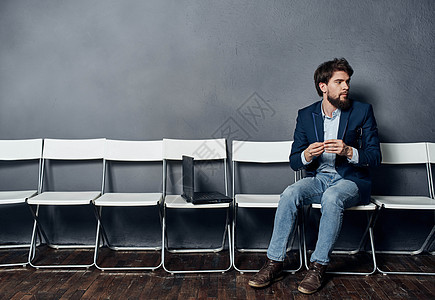 身穿西装的商务人士坐在一张椅子上 站在笔记本电脑工作生活方式面前人士沉思就业正装衬衫面试经理商业智力会议图片