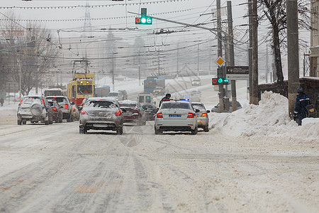 俄罗斯图拉-2020年2月13日 市立汽车在大雪降雪时用警车停在交通灯前的十字路口图片