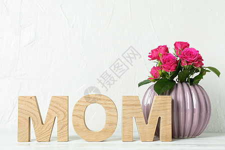 在 tex 的白色桌面空间上题词妈妈和带粉红玫瑰的花瓶图片