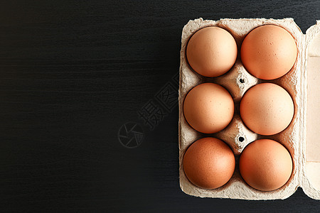 黑底 文字空间和顶视图的纸箱盒装鸡蛋中的棕色鸡蛋图片