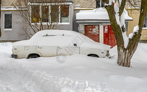 暴风雪过后的城市街道 汽车被困在冰雪之下 车辆被埋在路上的雪堆中 冬天大雪过后的停车场 未清洁的道路 破纪录的降雪量街道灾难交通图片