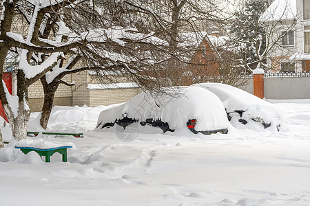 暴风雪过后的城市街道 汽车被困在冰雪之下 车辆被埋在路上的雪堆中 冬天大雪过后的停车场 未清洁的道路 破纪录的降雪量交通天气危险图片