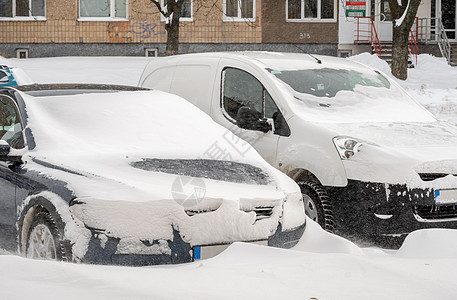 暴风雪过后的城市街道 汽车被困在冰雪之下 车辆被埋在路上的雪堆中 冬天大雪过后的停车场 未清洁的道路 破纪录的降雪量气候预报情况图片