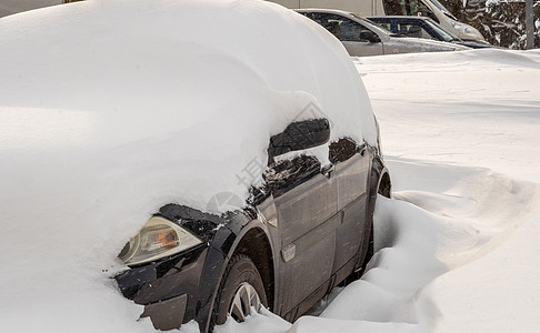 暴风雪过后的城市街道 汽车被困在冰雪之下 车辆被埋在路上的雪堆中 冬天大雪过后的停车场 未清洁的道路 破纪录的降雪量风暴沉淀灾难图片