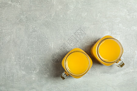 玻璃罐 灰色背景上有新鲜橙汁 文字空间和顶部视图的玻璃罐图片