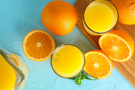 玻璃器械 薄荷和剪切板中含有新鲜橙汁 彩色背景为橙子 最高视图 新鲜天然饮料图片