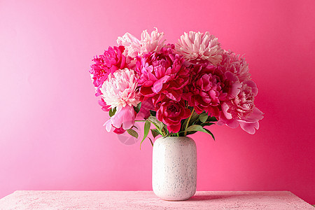 花瓶 在粉红色的桌子上放着一束美丽的牡丹花 背景是 tex 的颜色空间妈妈们问候语周年牡丹花朵紫色墙纸婚礼生日玻璃图片