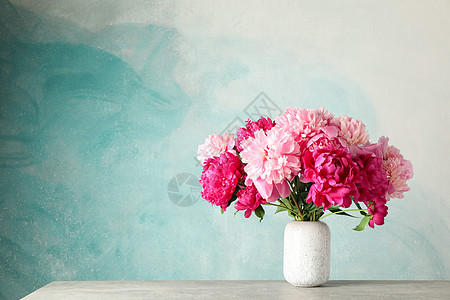 在蓝色背景空间的灰色桌子上放着一束美丽牡丹的花瓶 用于 tex玻璃花束植物纪念日牡丹紫色妈妈们庆典周年生日图片