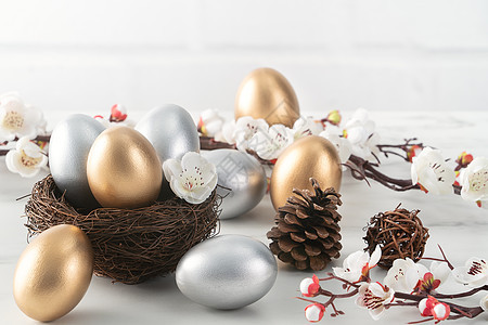 金蛋和银色复活节鸡蛋 在巢中与白梅花乐趣木头礼物篮子风格庆典乡村季节金子装饰图片