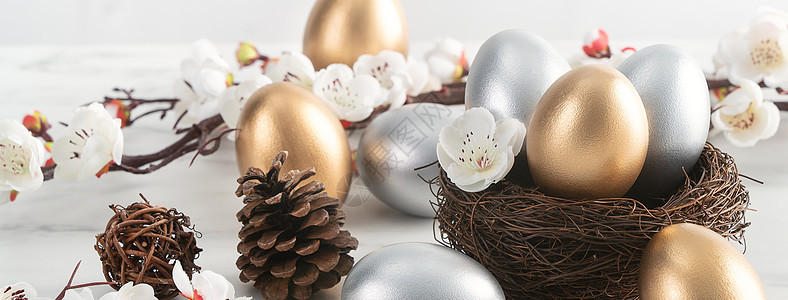 金蛋和银色复活节鸡蛋 在巢中与白梅花假期李子乐趣礼物乡村篮子卡片庆典桌子装饰图片