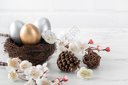 金蛋和银色复活节鸡蛋 在巢中与白梅花乐趣庆典木头卡片篮子金子假期季节桌子礼物图片