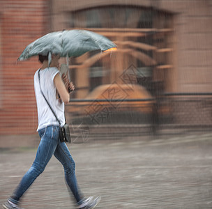 雨天人们在街上走着运动人群风暴城市季节街道冷藏天气路面女孩图片