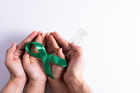 世界肾日 男女手握着对肾病的绿丝带认识 孤立白种背景 16器官捐款机构诊断保险沮丧药品橙子治疗病人图片