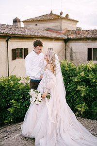 在意大利托斯卡纳的一座古老的酒庄别墅举行婚礼 旧酒厂别墅屋顶上的新婚夫妇露肩魅力夫妻投标连衣裙发型女士金发女郎羽毛冒充图片