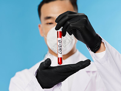 红色血液一个亚洲人出现在保护面罩血液测试中 黑色手套诊断蓝背景的黑手套诊断器背景
