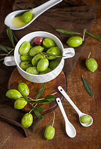 黑色背景的橄榄油和橄榄枝食物植物树林收成烹饪油壶厨房草本植物桌子水果图片