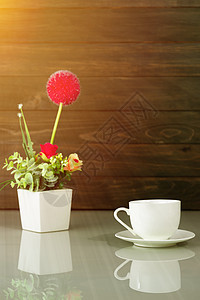 桌上的咖啡杯和人造花花瓶花束甲板木头黑色杯子礼物玫瑰红色咖啡店办公室桌子图片