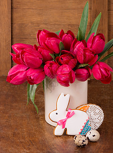 粉红郁金香和复活节兔子饼干 在木制背景庆典花束假期卡片妈妈们问候语木头礼物植物蓝色图片