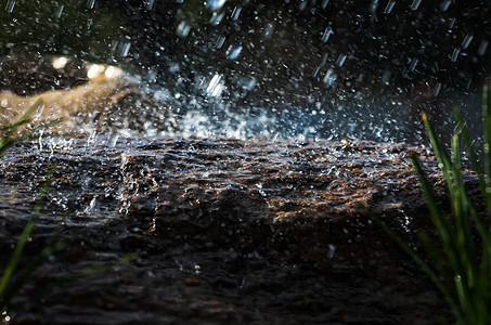 雨水滴落到石头上棕色黑色水坑天气鹅卵石下雨季节白色岩石飞溅图片