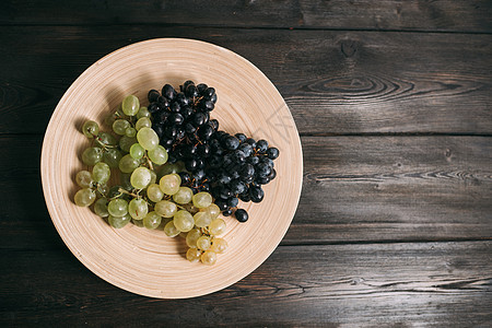 在木制桌上的一块盘子上的葡萄酒厂黑板大理石营养紫色藤蔓食物菜单木头桌子图片