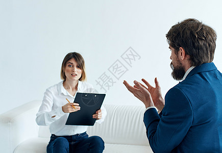 穿着经典西装的商务人士和坐在沙发上 文件在心理学家手中的妇女 笑声文档女士公司女性合伙工作男人团体成人电脑图片