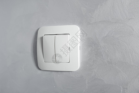 安装在浅灰色墙上的白色光开关a塑料机械开关力量生活燃料技术活力按钮家庭电气控制房子图片