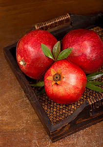 木制背景上的石榴水果的提取种子植物农业皮肤甜点叶子花园桌子圆圈果汁图片