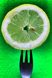 柠檬片刺在绿背景的叉子上营养养分食物热带饮食素食水果健康饮食甜点圆圈图片