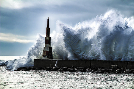 巨大的波浪冲破断裂水和灯塔气候戏剧性天气海洋天空休息风暴海滩碰撞海岸图片
