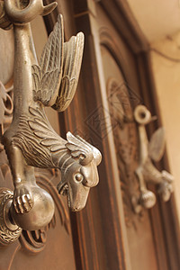 旧木制门上装有神话龙形的金金门敲门器风化入口安全文化青铜艺术雕塑动物金属木头图片