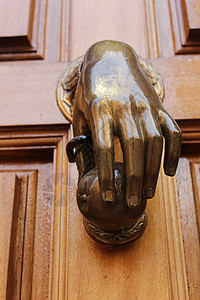 旧木制门上有手形状的金敲门机入口门把手建筑学古董金子房子青铜装饰品风格宏观图片