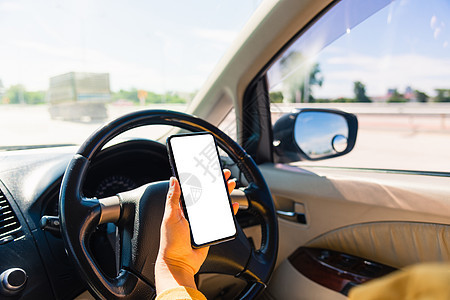女人在车里 在开车时用手拿着手机空白屏幕图片