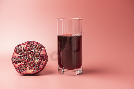 一杯红背景的石榴果汁和石榴糖图片