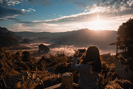 这名女孩在泰国Phayao省Phu Lang Ka山地标的阳台酒吧用智能手机照相运动女性旅行城市酒吧自由自拍游客快乐照片图片