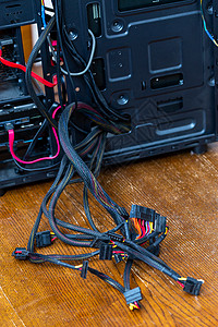 从打开的黑色 Pc 案子中找出的一系列计算机电线  有选择性焦点的闭合技术困惑职业内脏案件硬件修理挫折地面危机图片